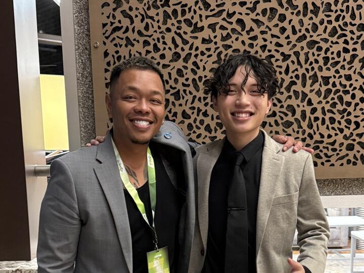 Two Lorem, Inc team members smiling at a conference